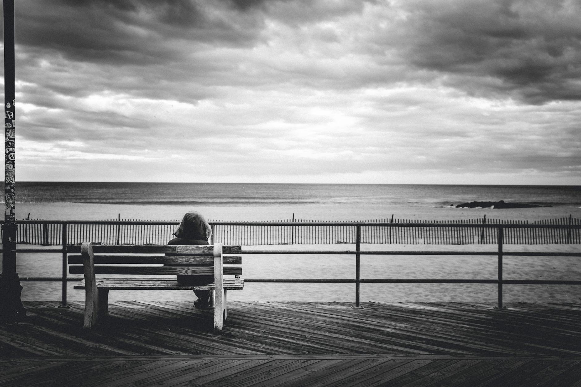 woman sitting on bench on a wooden pier