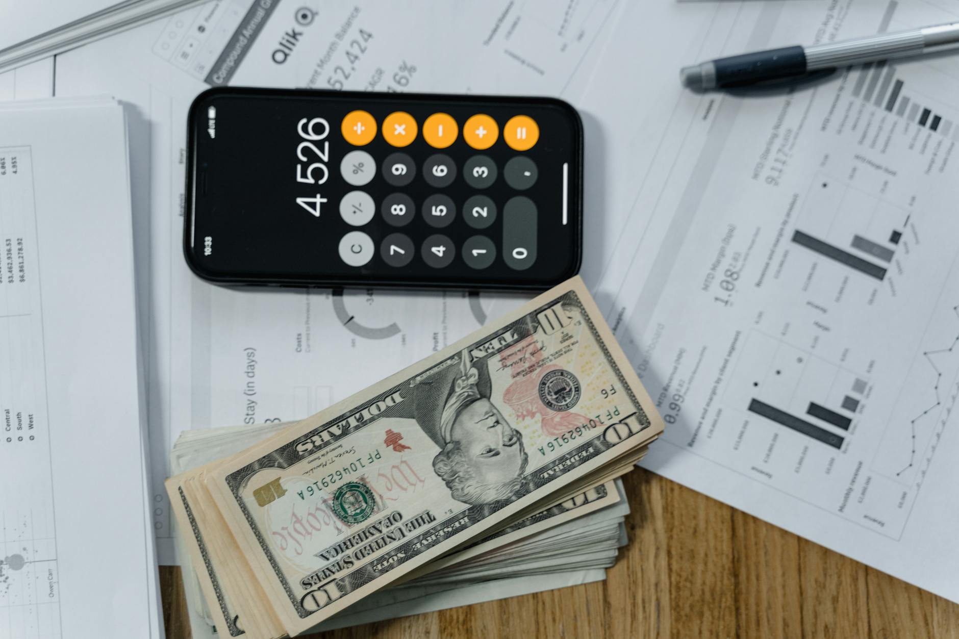 cash money and a calculator on white paper printout