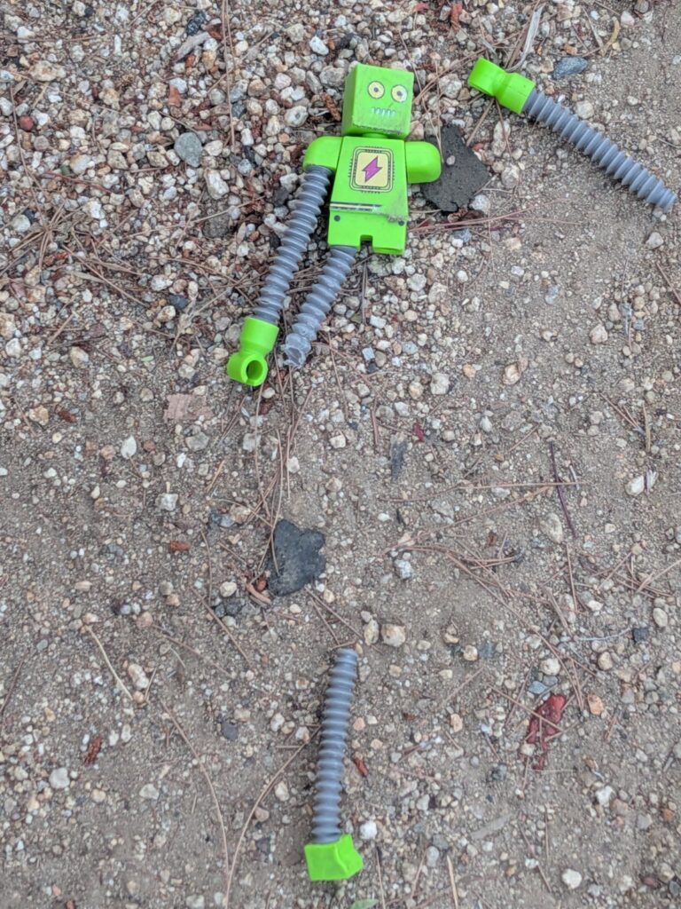 A broken toy robot, abandoned.